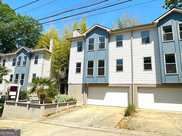 738 Saint Charles Ave NE, Atlanta, GA 30306 - view of property featuring an attached garage, a chimney, stucco siding, and driveway
