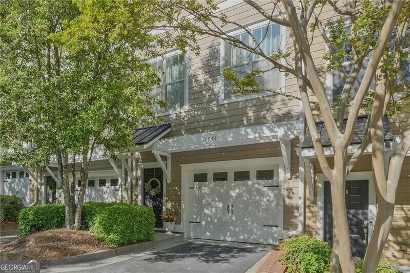 1971 Sterling Oaks Cir, Brookhaven, GA 30319 - view of front of house featuring an attached garage, a standing seam roof, driveway, and metal roof