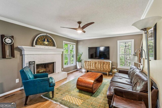 5876 Bridgemont Pl NW, Acworth, GA 30101 - living area with a textured ceiling, visible vents, wood finished floors, ceiling fan, and ornamental molding