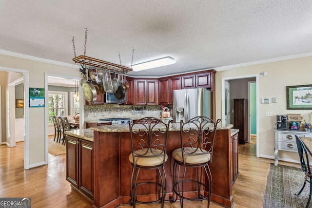 5876 Bridgemont Pl NW, Acworth, GA 30101 - kitchen featuring a textured ceiling, light wood-style floors, appliances with stainless steel finishes, and tasteful backsplash