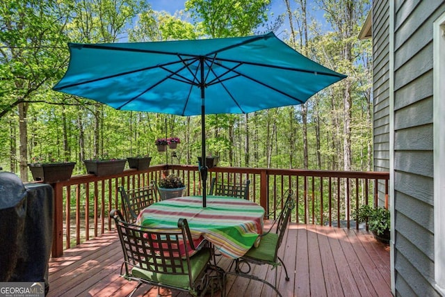 5876 Bridgemont Pl NW, Acworth, GA 30101 - wooden deck with outdoor dining space, a wooded view, and a grill
