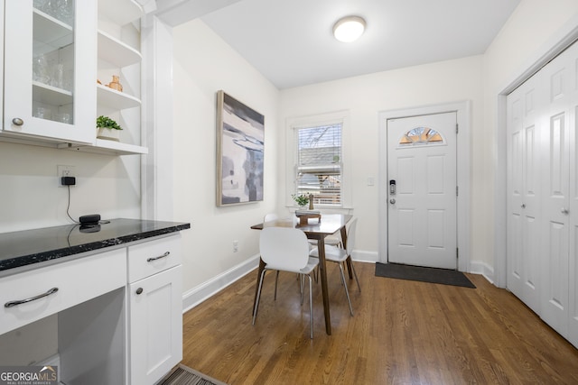 dining space with dark wood-type flooring and baseboards