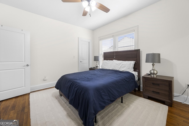 bedroom with ceiling fan, baseboards, and wood finished floors
