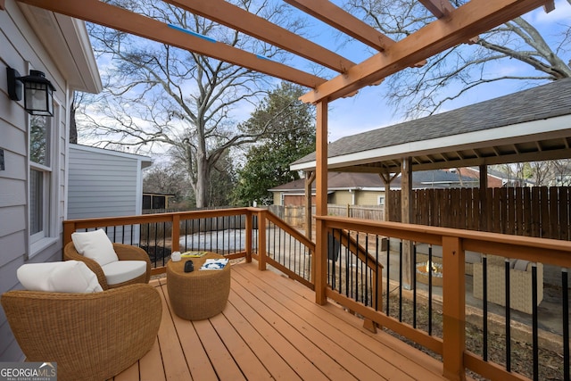 deck featuring fence, a pergola, and an outdoor structure