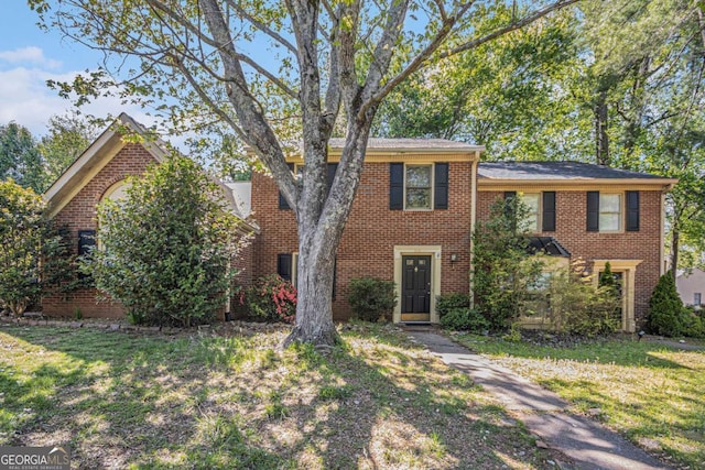 view of front facade with a front lawn and brick siding
