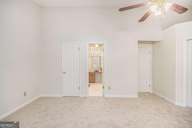 unfurnished bedroom with high vaulted ceiling, baseboards, and carpet flooring