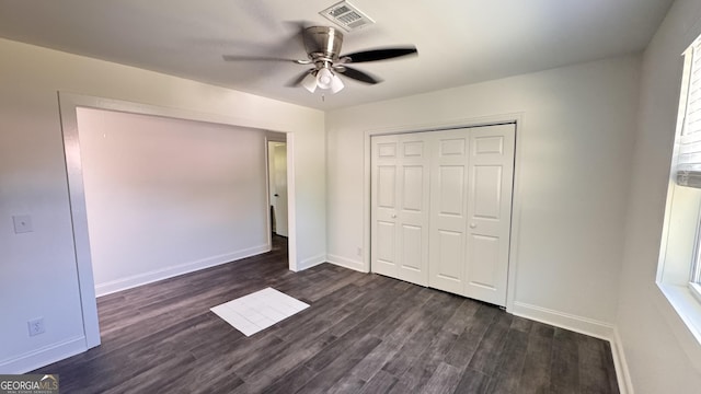 unfurnished bedroom with visible vents, a closet, dark wood-style flooring, baseboards, and ceiling fan