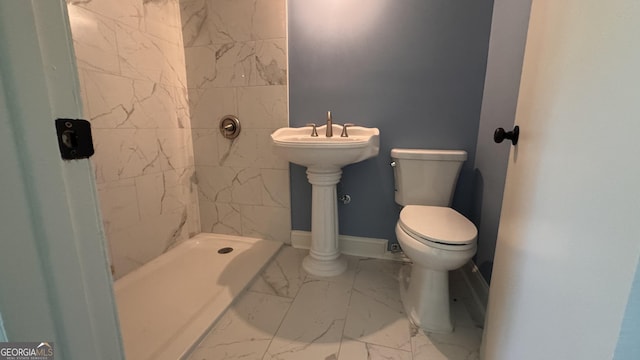 full bathroom with marble finish floor, toilet, and a tile shower