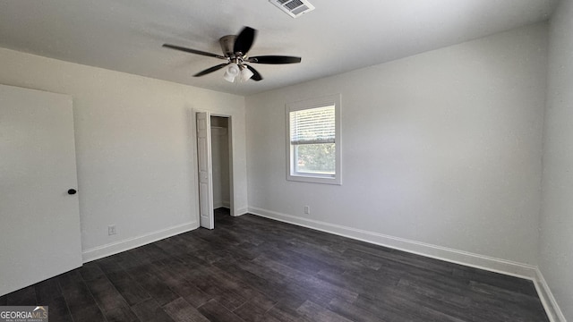 unfurnished bedroom with a ceiling fan, a closet, baseboards, dark wood-style flooring, and visible vents