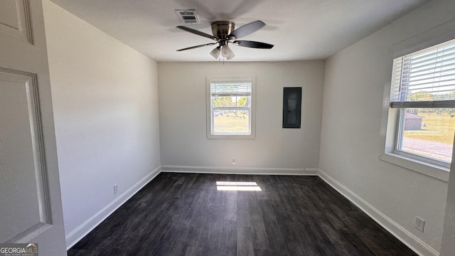 spare room with electric panel, dark wood finished floors, baseboards, visible vents, and a ceiling fan
