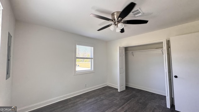 unfurnished bedroom with dark wood-style flooring, baseboards, visible vents, a ceiling fan, and a closet