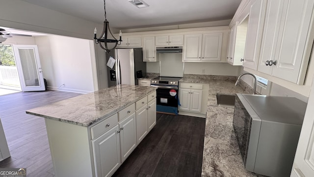 kitchen featuring stainless steel appliances, a sink, dark wood finished floors, visible vents, and under cabinet range hood