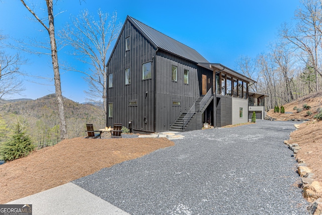 631 Bent Grass, Clayton, GA 30525 - view of front of house with stairs, metal roof, driveway, central AC unit, and a standing seam roof
