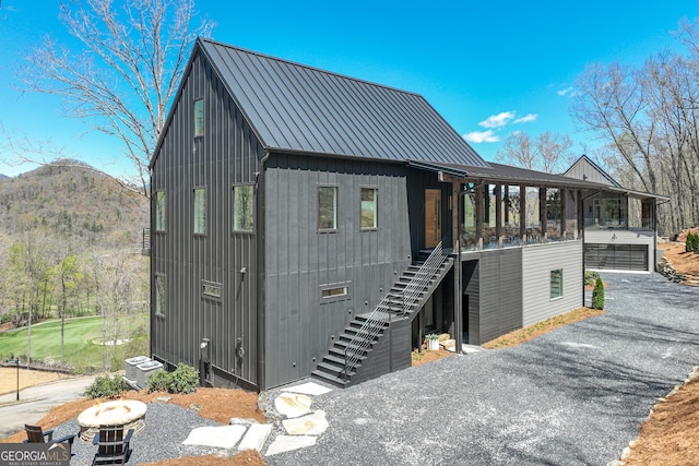 631 Bent Grass, Clayton, GA 30525 - view of front facade with stairway, metal roof, a mountain view, cooling unit, and a garage