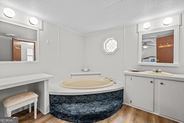 82 Dogwood Ct, Sparta, GA 31087 - bathroom with a bath, wood finished floors, a textured ceiling, and vanity