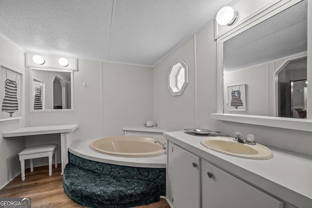 82 Dogwood Ct, Sparta, GA 31087 - bathroom featuring a bath, wood finished floors, a textured ceiling, and vanity