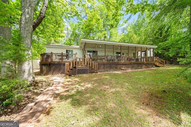 82 Dogwood Ct, Sparta, GA 31087 - back of property featuring a wooden deck, stairs, and a yard