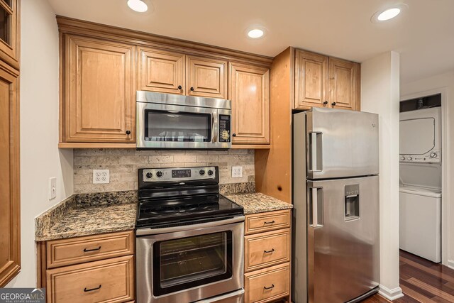 3481 Lakeside Dr NE Unit 1504, Atlanta, GA 30326 - kitchen with stone countertops, stacked washing maching and dryer, appliances with stainless steel finishes, and tasteful backsplash