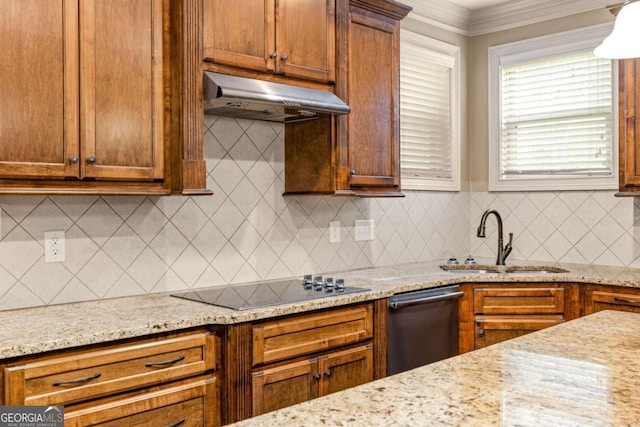 kitchen with brown cabinets, black electric cooktop, light stone counters, under cabinet range hood, and a sink
