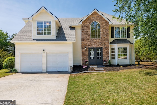 24 Hamilton Dr, Jefferson, GA 30549 - view of front of property with a front lawn, concrete driveway, french doors, stone siding, and roof with shingles