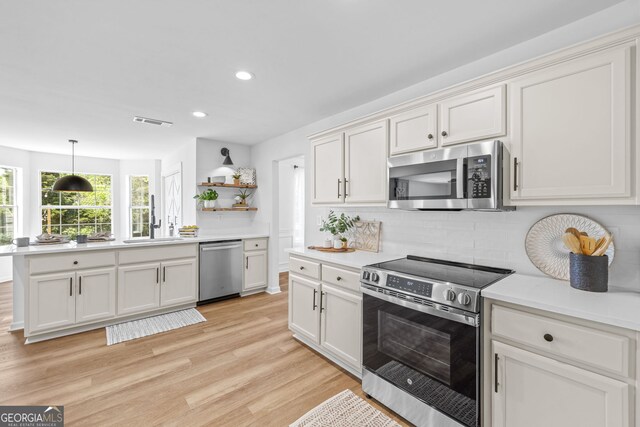 24 Hamilton Dr, Jefferson, GA 30549 - kitchen with a sink, decorative backsplash, open shelves, light countertops, and appliances with stainless steel finishes