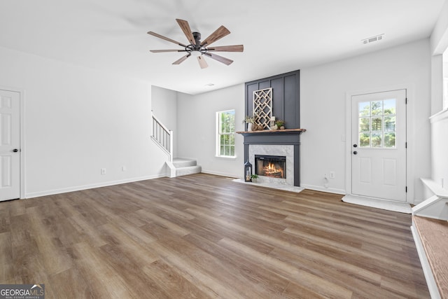 24 Hamilton Dr, Jefferson, GA 30549 - unfurnished living room featuring stairway, a ceiling fan, wood finished floors, a premium fireplace, and visible vents