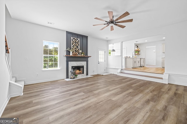 24 Hamilton Dr, Jefferson, GA 30549 - unfurnished living room with a ceiling fan, light wood finished floors, visible vents, and a premium fireplace