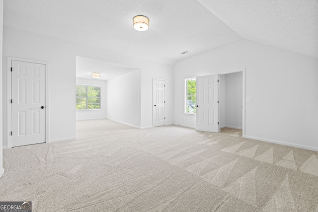 24 Hamilton Dr, Jefferson, GA 30549 - unfurnished living room featuring baseboards, vaulted ceiling, and carpet flooring