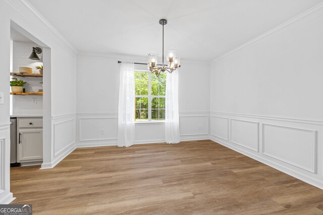 24 Hamilton Dr, Jefferson, GA 30549 - unfurnished dining area featuring ornamental molding, light wood finished floors, a notable chandelier, and a wainscoted wall