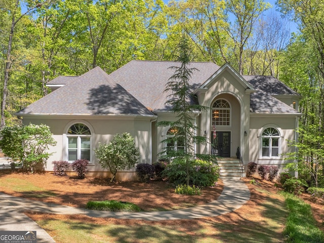view of front of house with roof with shingles and stucco siding