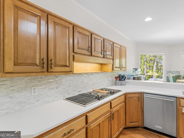 kitchen with stainless steel dishwasher, decorative backsplash, crown molding, light countertops, and black electric cooktop