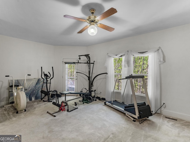 exercise area featuring baseboards, ceiling fan, carpet floors, and visible vents