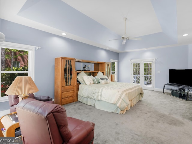 carpeted bedroom featuring access to outside, recessed lighting, ceiling fan, and a tray ceiling