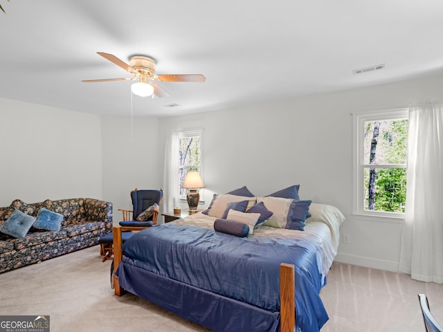 carpeted bedroom with visible vents, baseboards, and ceiling fan
