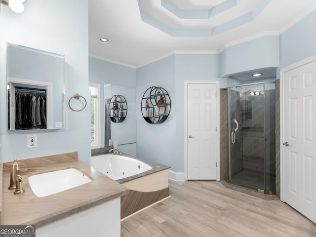 bathroom with crown molding, wood finished floors, a jetted tub, recessed lighting, and a shower stall