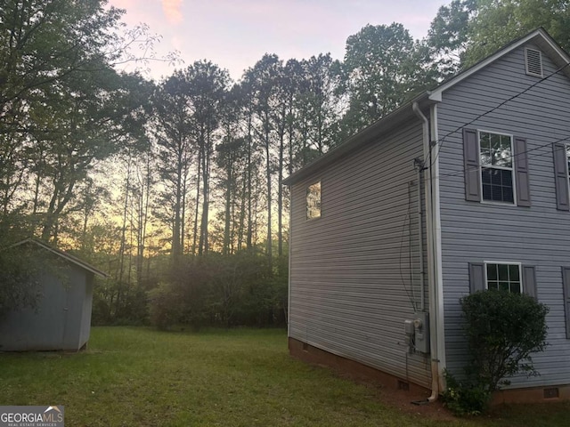 691 Aberdeen Dr, Stone Mountain, GA 30083 - property exterior at dusk featuring crawl space, a storage unit, and a lawn