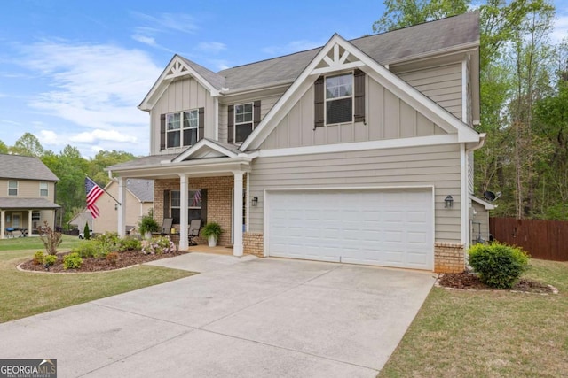craftsman house featuring board and batten siding, an attached garage, driveway, covered porch, and brick siding