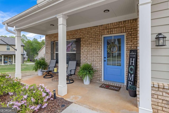 entrance to property featuring brick siding and a porch