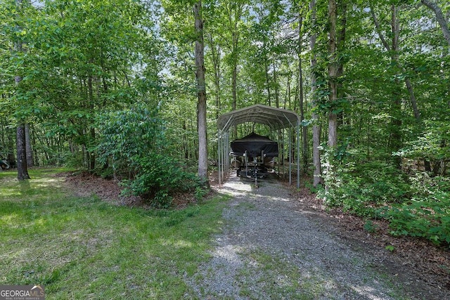 view of yard featuring a carport and gravel driveway