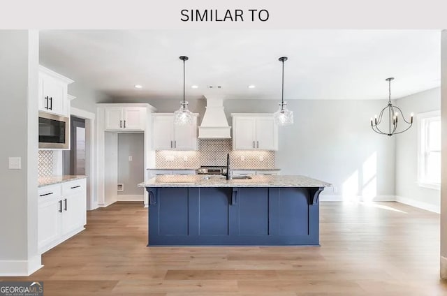 104 Reedy Ct, Perry, GA 31069 - kitchen with custom range hood, stainless steel microwave, white cabinets, tasteful backsplash, and recessed lighting