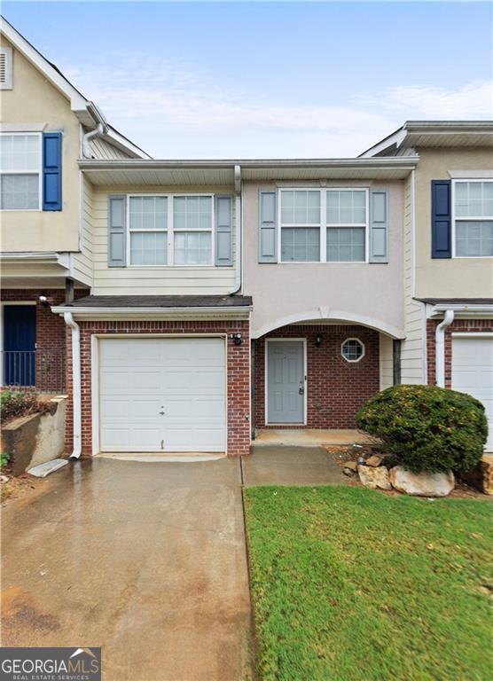 720 Georgetown Ln, Jonesboro, GA 30236 - townhome / multi-family property with brick siding, stucco siding, driveway, and a garage