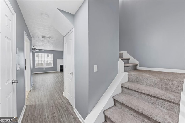 720 Georgetown Ln, Jonesboro, GA 30236 - staircase with visible vents, baseboards, a ceiling fan, wood finished floors, and a fireplace