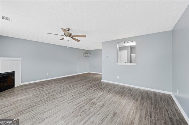 720 Georgetown Ln, Jonesboro, GA 30236 - unfurnished living room with a tiled fireplace, baseboards, visible vents, wood finished floors, and ceiling fan