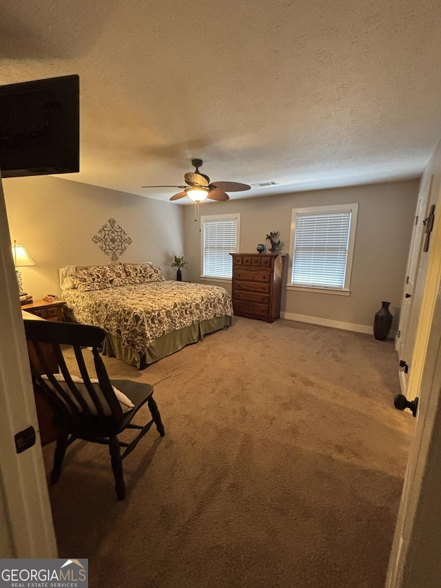 bedroom featuring carpet floors, a textured ceiling, a ceiling fan, and baseboards