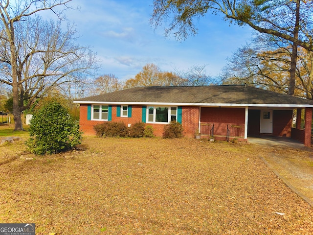 single story home with brick siding, driveway, and a carport