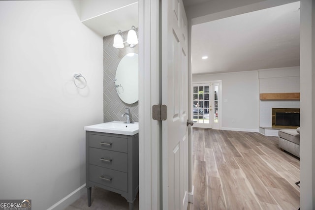 6101 River Rd Apt 20, Columbus, GA 31904 - bathroom featuring vanity, baseboards, a brick fireplace, and wood finished floors