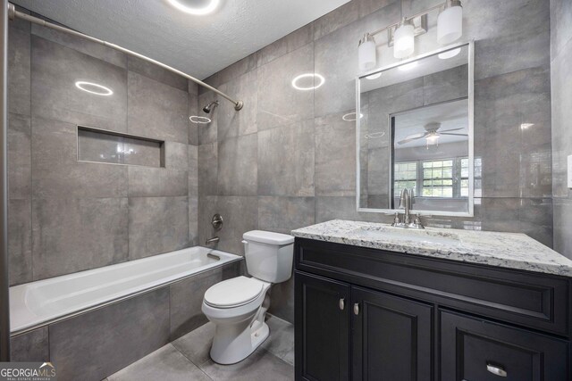 6101 River Rd Apt 20, Columbus, GA 31904 - full bath featuring a textured ceiling, toilet, tile walls, tile patterned flooring, and tiled shower / bath combo