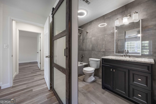 6101 River Rd Apt 20, Columbus, GA 31904 - bathroom featuring wood finished floors, shower / bathtub combination, toilet, vanity, and tile walls