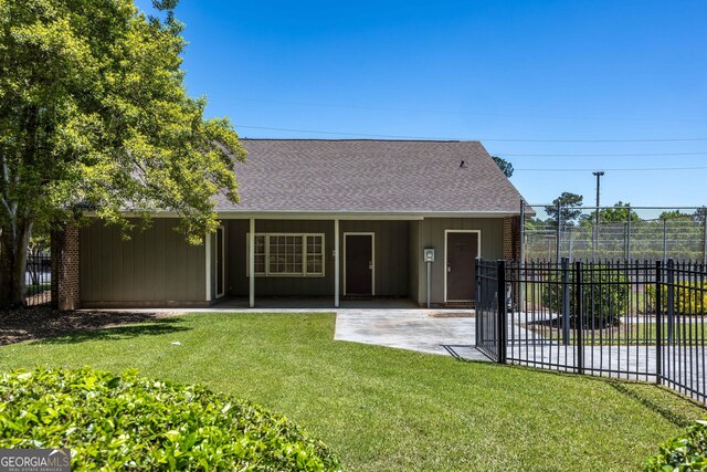 6101 River Rd Apt 20, Columbus, GA 31904 - rear view of property featuring fence, a lawn, roof with shingles, and a patio