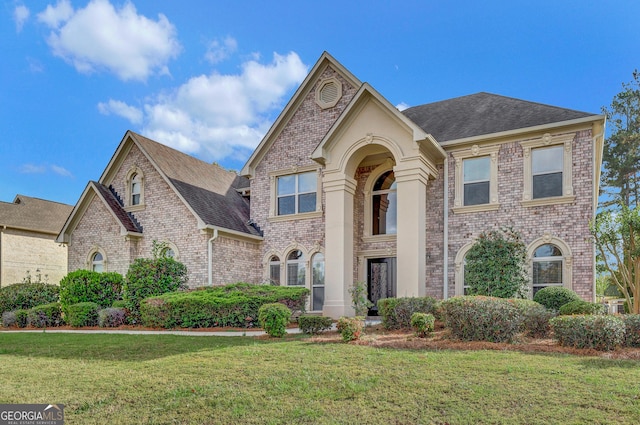 view of front of home with brick siding and a front yard
